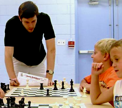 Instructor teaching chess to kid